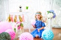 A portrait of a beautiful little girl in a studio decorated many color balloons