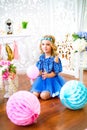 A portrait of a beautiful little girl in a studio decorated many color balloons