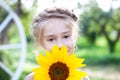 Portrait of a beautiful little girl with a sunflower. concept of childhood, health and lifestyle. child is hiding behind a flower.