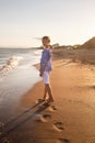 Portrait of beautiful little girl walking in sea waves in sunset light Royalty Free Stock Photo