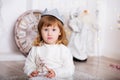 Portrait of a beautiful little girl in a white dress and a crown