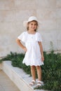 Portrait beautiful little girl in white dress and hat. Happy smiled five year old girl Royalty Free Stock Photo