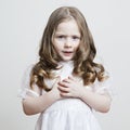 Portrait of a beautiful little girl in a white dress and veil on