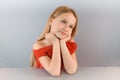 Portrait of a beautiful little sad blond girl in a white shirt, isolated on a white background. Royalty Free Stock Photo