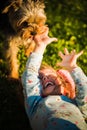 Portrait of a beautiful little 2 years old girl lying on grass and laughing with york terrier Royalty Free Stock Photo