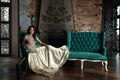 Portrait of beautiful magnificent fashion model woman wearing fashionable silver evening gown posing in vintage palace interior Royalty Free Stock Photo