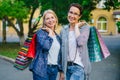 Portrait of beautiful mature ladies holding shopping bags smiling outdoors Royalty Free Stock Photo