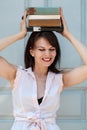 Attractive mature woman posing with some books on her head Royalty Free Stock Photo