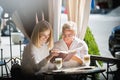 Portrait of beautiful mature mother and her daughter holding cup sitting at home Royalty Free Stock Photo