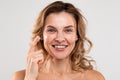 Portrait Of Beautiful Mature Woman Applying Nourishing Cream On Face Royalty Free Stock Photo