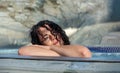 Portrait of beautiful mature woman with dark curly hair relaxes contend happy in holidays summer sun in the spa wellness whirlpool Royalty Free Stock Photo