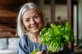 Portrait of beautiful mature woman taking care of plants on balcony. Spending free weekend at home. Royalty Free Stock Photo