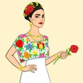 Portrait of the beautiful Mexican woman in a festive dress with a rose in a hand.