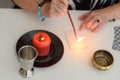 Portrait of beautiful middle age woman sits near a fortune teller desk with a tarot cards, black pendulum and candles. Royalty Free Stock Photo