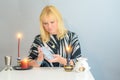 Portrait of beautiful middle age woman sits near a fortune teller desk with a tarot cards and candles. Royalty Free Stock Photo