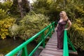 Portrait of beautiful middle aged woman posing on a small bridge in the middle of a french green park Royalty Free Stock Photo