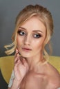 Portrait of a beautiful miniature bride in a lace dress. Hair with curls. Emphasis in make-up on the eyes.Blonde.