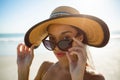 Beautiful woman in hat looking over sunglasses on the beach Royalty Free Stock Photo