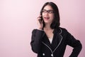 Portrait beautiful modern asian business woman talking on mobile phone isolated on pink background Royalty Free Stock Photo