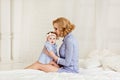 Portrait of a beautiful mom blonde and a little girl baby with b