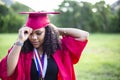 Portrait of a beautiful multiethnic woman putting on her graduation cap and gown Royalty Free Stock Photo