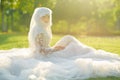 Portrait of a beautiful muslim bride with make up in white wedding dress with beautiful white headdress natural light.