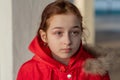 Portrait of a beautiful nine year old little girl. School child in winter clothes on the street. Girl 9 years old