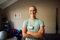 Portrait of beautiful nurse standing cross-armed in exercise room. Royalty Free Stock Photo