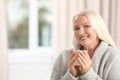 Portrait of beautiful older woman with cup of tea against blurred background. Space Royalty Free Stock Photo