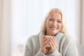 Portrait of beautiful older woman with cup of tea against blurred Royalty Free Stock Photo