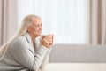 Portrait of beautiful older woman with cup of tea sitting at table indoors Royalty Free Stock Photo