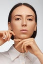 Portrait of a beautiful pacified woman in a white shirt on a light background Royalty Free Stock Photo