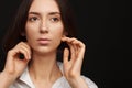 Portrait of a beautiful pacified woman in a white shirt on a light background