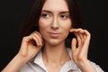 Portrait of a beautiful pacified woman in a white shirt on a light background