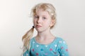 Portrait of a beautiful pensive arrogant Caucasian girl with messy blonde hair looking in camera. Moody grumpy preschool child kid Royalty Free Stock Photo