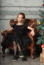 Portrait of a beautiful pensive girl in black near the Christmas tree at Christmas Royalty Free Stock Photo