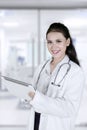 Beautiful physician holding tablet in the hospital