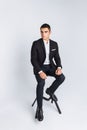 Portrait of the beautiful posing in a Studio, White background, Stylish business man, Stylish man sitting on a designer chair Royalty Free Stock Photo