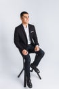 Portrait of the beautiful posing in a Studio, White background, Stylish business man, Stylish man sitting on a designer chair Royalty Free Stock Photo