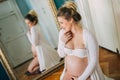 Portrait of a beautiful pregnant woman in front of a mirror at home Royalty Free Stock Photo