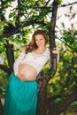 Portrait of a beautiful pregnant woman next to cherry tree Royalty Free Stock Photo