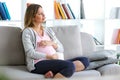 Beautiful pregnant woman relaxing on the sofa at home