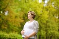 Portrait of a beautiful pregnant young woman at the fall park. Expectant mother. Motherhood