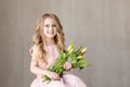 Portrait of very beautiful young pretty girl with yellow flowers tulips, smiling. Indoor photo. Spring theme. Close-up. Copy space Royalty Free Stock Photo