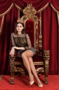 Portrait of beautiful queen sitting on throne