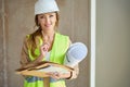 Portrait of beautiful realtor with rolls of blueprints of houses