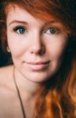 Vertical portrait of a beautiful red-haired curly girl with make-up and jewelry Royalty Free Stock Photo