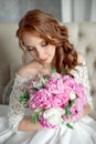 Portrait of beautiful red-haired girl sitting, smiling on big arm-chair. Royalty Free Stock Photo