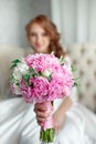 Portrait of beautiful red-haired girl sitting, smiling on big arm-chair. Royalty Free Stock Photo