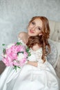 Portrait of beautiful red-haired girl sitting, smiling on big arm-chair. Royalty Free Stock Photo